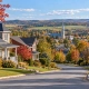 Vue d’un quartier résidentiel québécois en automne avec village en arrière-plan